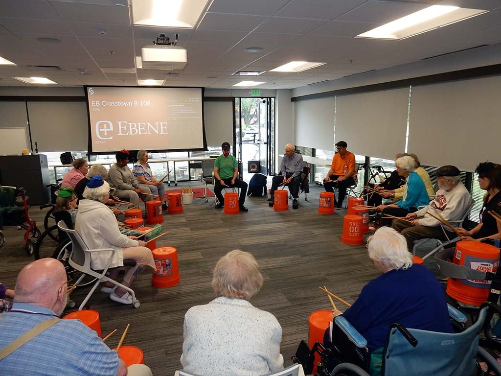 a group of seniors playing orange bucket drums